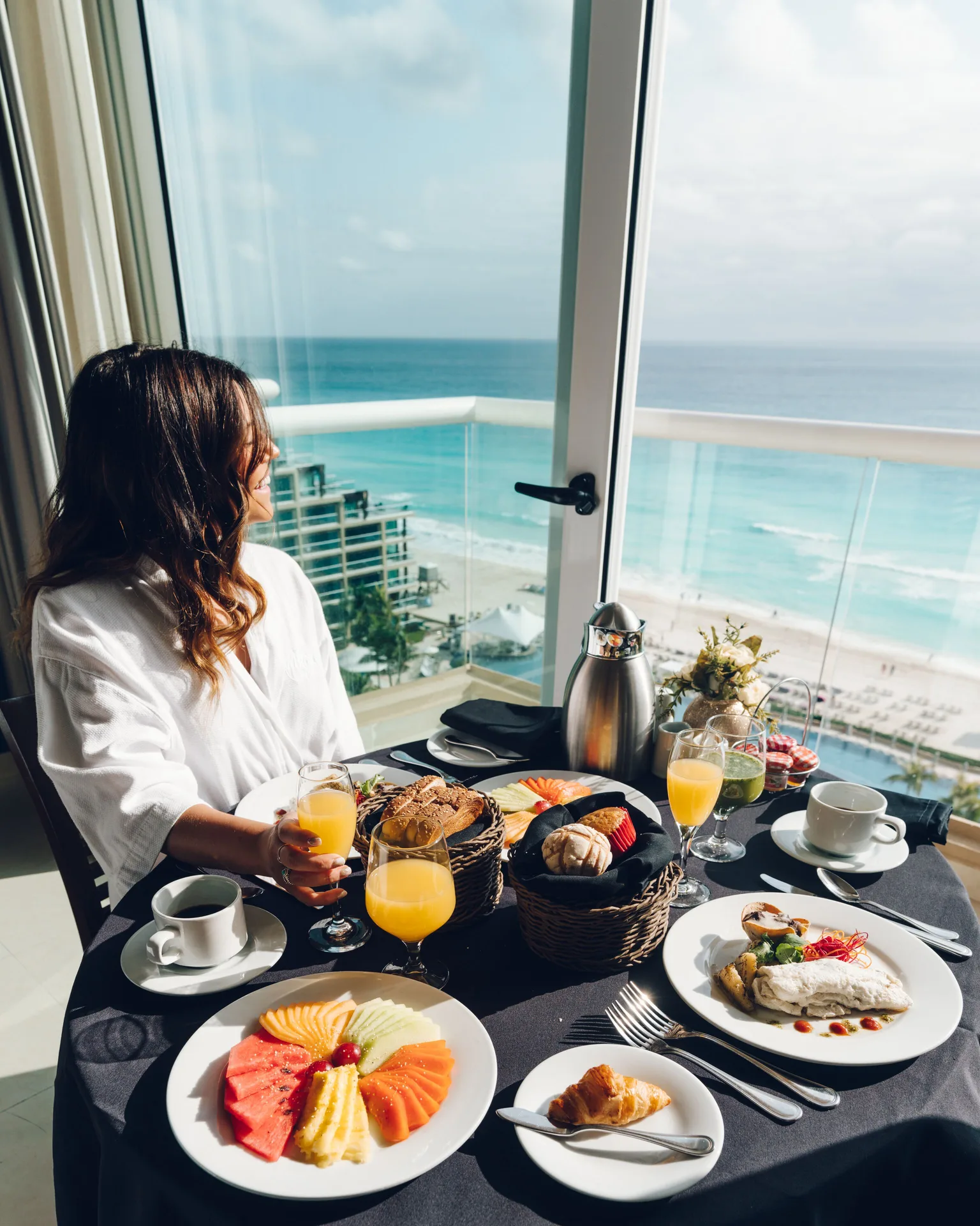 Guest enjoys breakfast by a balcony with ocean views at Hard Rock Hotel Cancun.