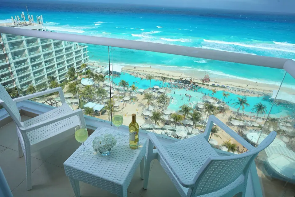 Deluxe Ocean View balcony with chairs overlooking the beach at Hard Rock Hotel Cancun.