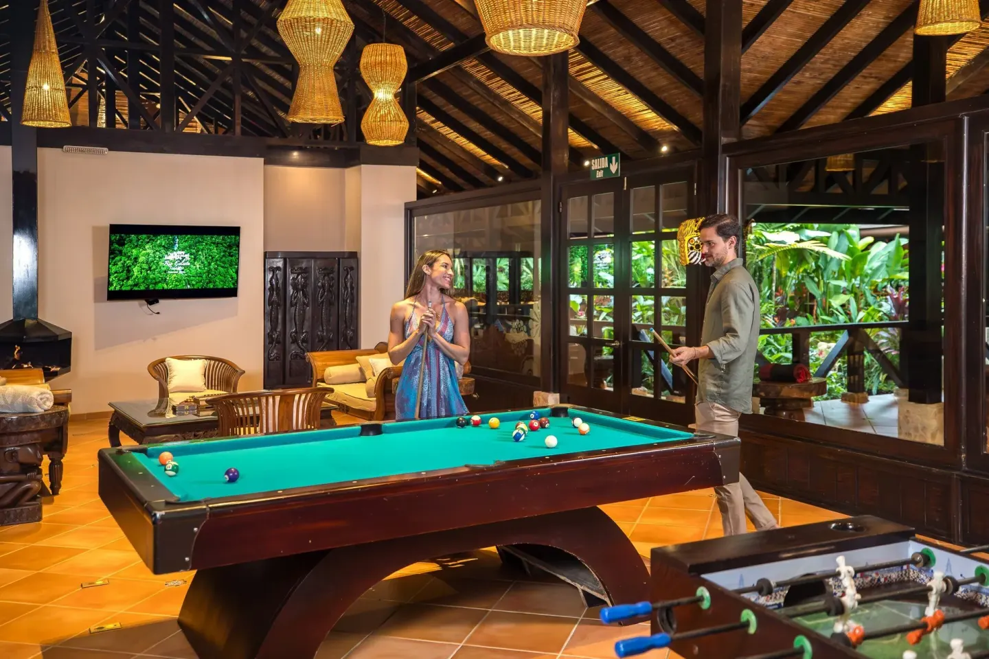 Guests play pool in a wood-beamed lounge at Hideaway Rio Celeste.