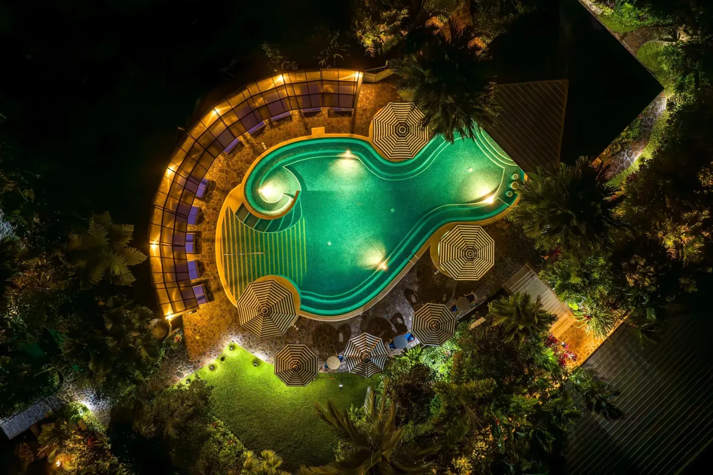 Aerial night view of the illuminated pool at Hideaway Rio Celeste.