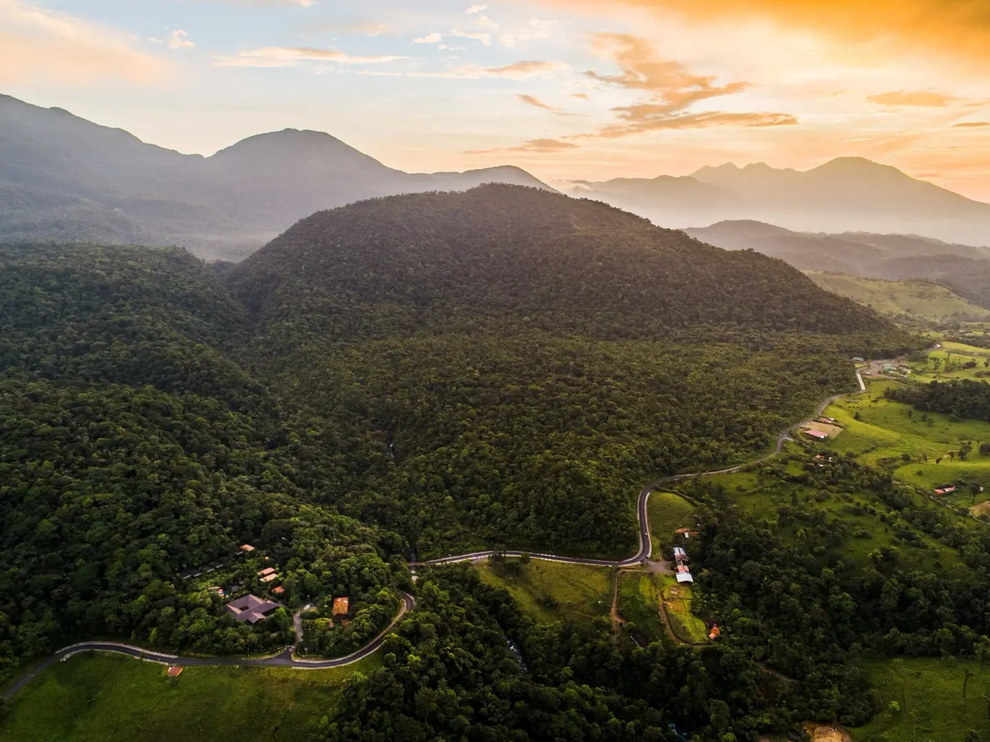 Sunset over forested mountains near Hideaway Rio Celeste.