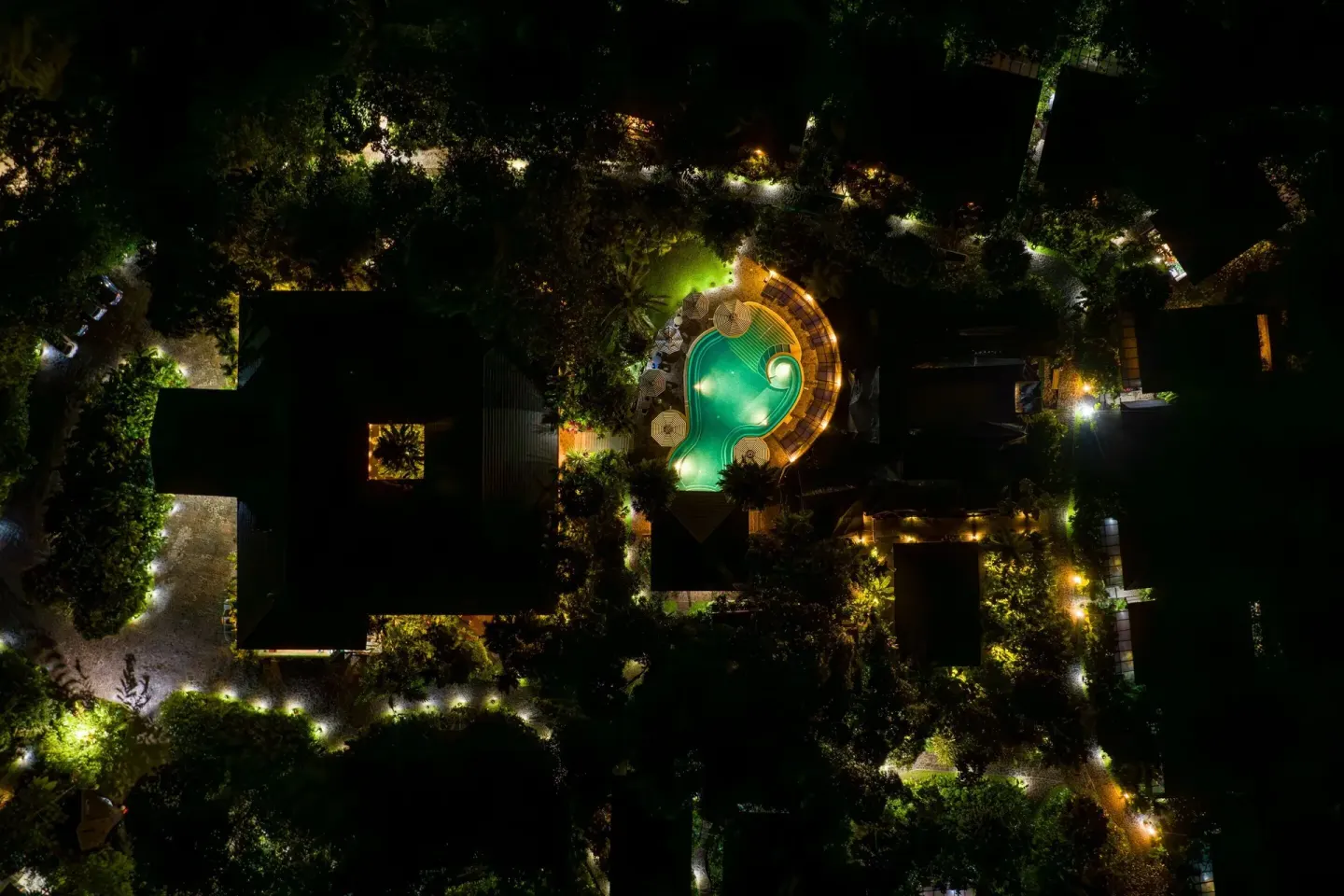 Night aerial view of the illuminated pool and paths at Hideaway Rio Celeste.