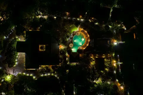 Night aerial view of the illuminated pool and paths at Hideaway Rio Celeste.
