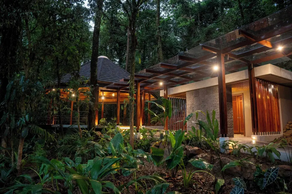 Illuminated resort walkway and buildings in the rainforest at Hideaway Rio Celeste.
