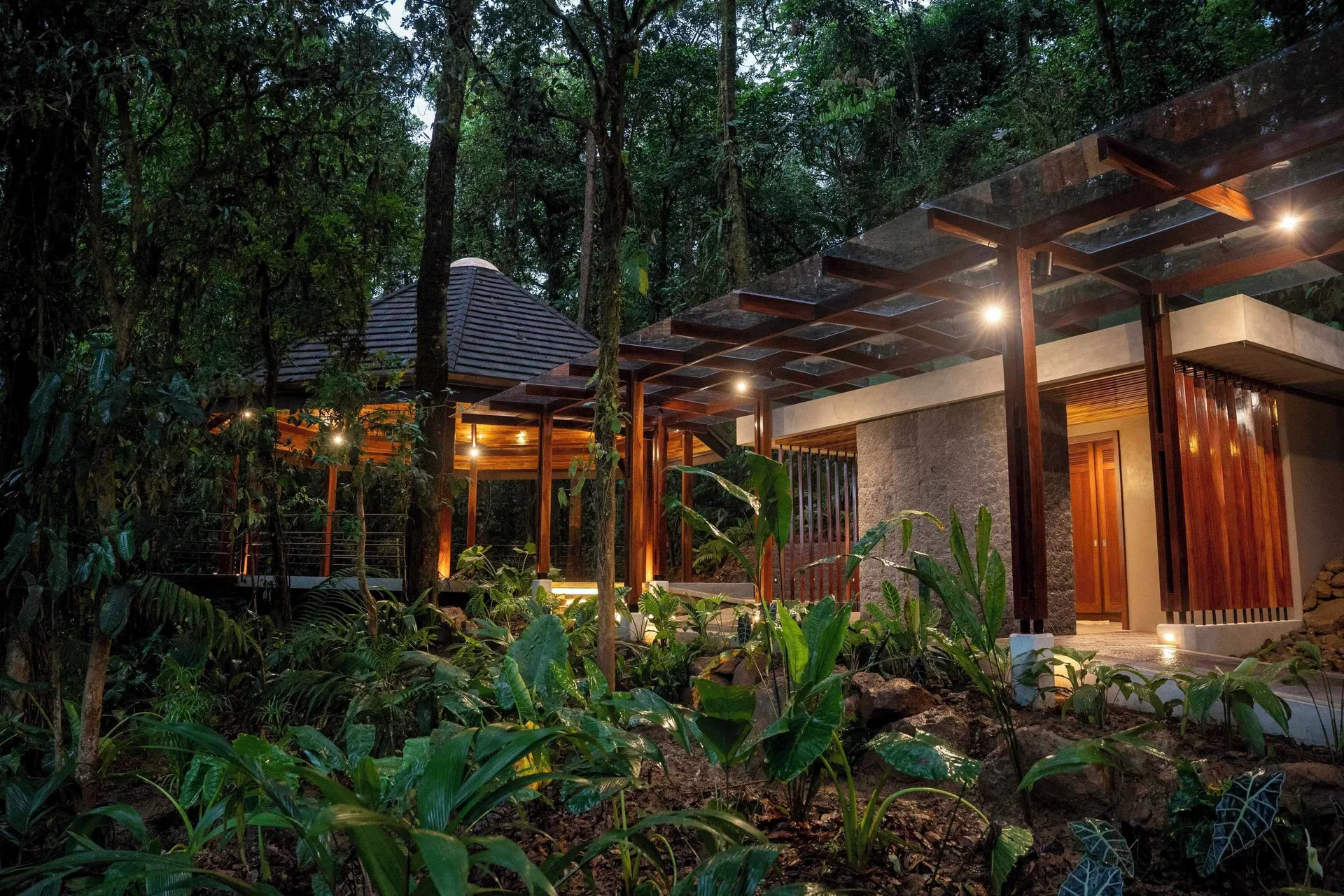 Illuminated resort walkway and buildings in the rainforest at Hideaway Rio Celeste.