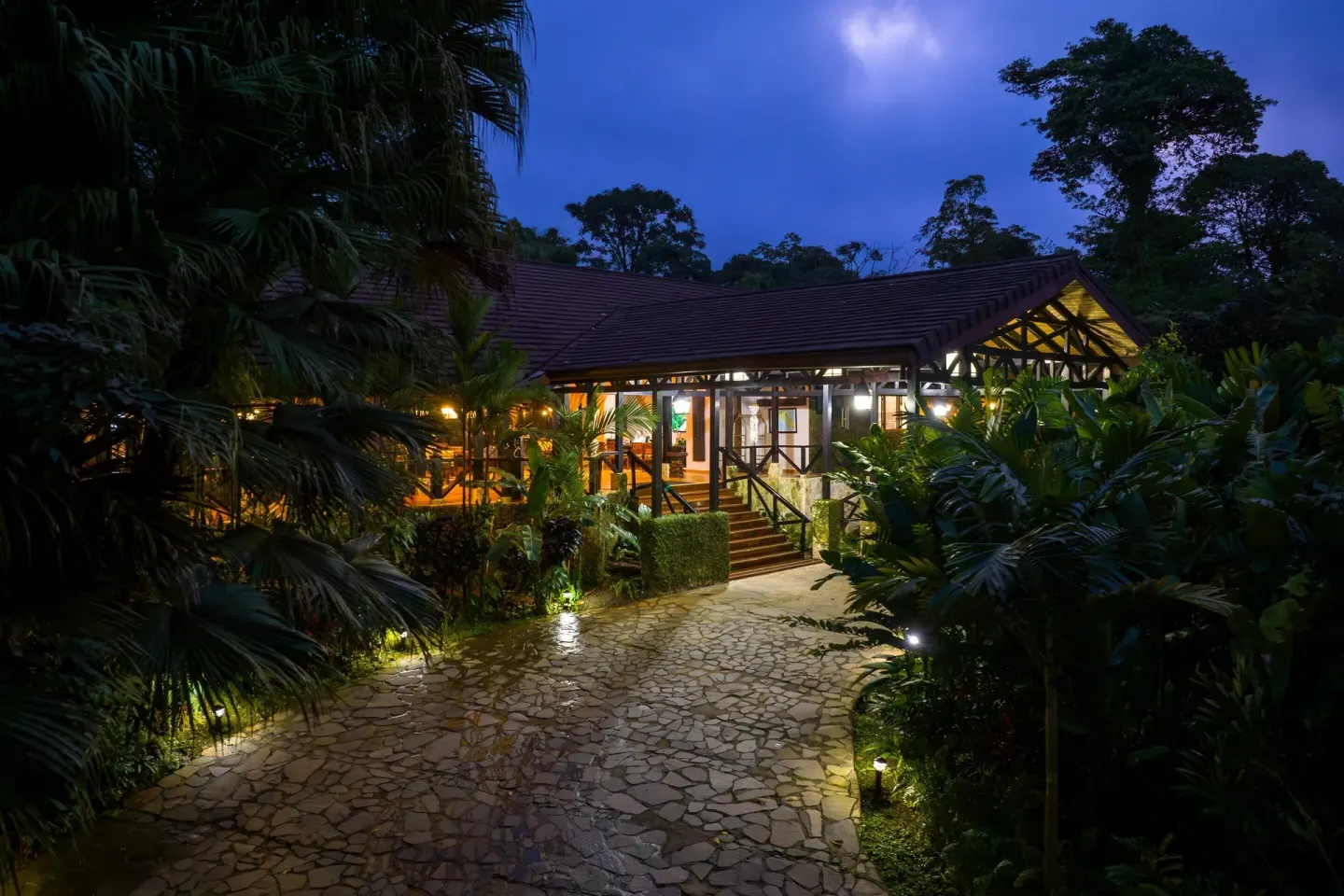 Illuminated resort building and stone path at night at Hideaway Rio Celeste.