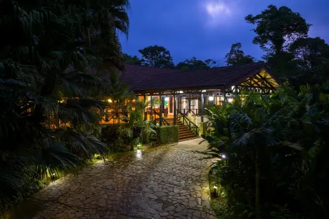 Illuminated resort building and stone path at night at Hideaway Rio Celeste.