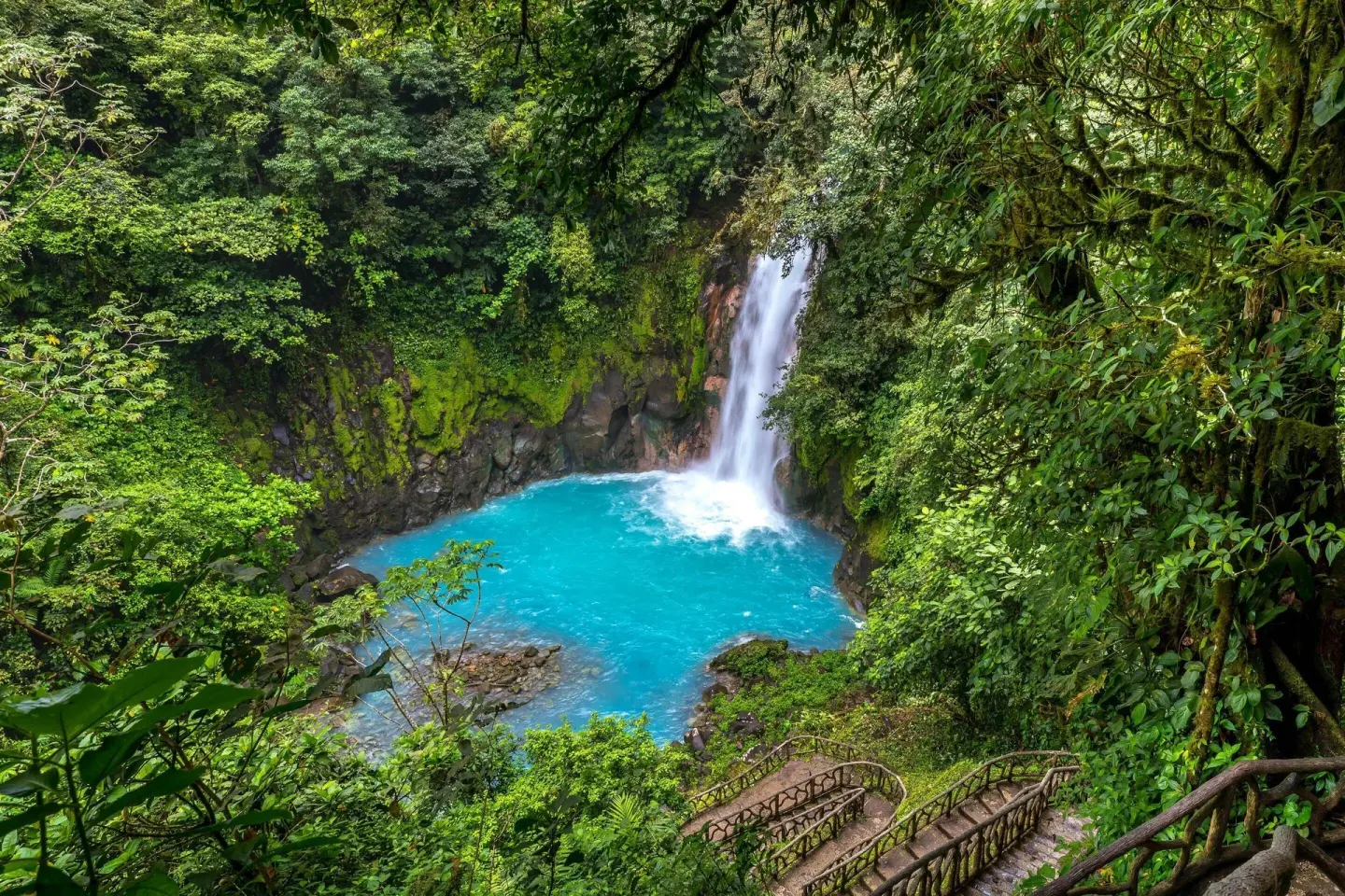 Turquoise waterfall pool surrounded by rainforest near Hideaway Rio Celeste.
