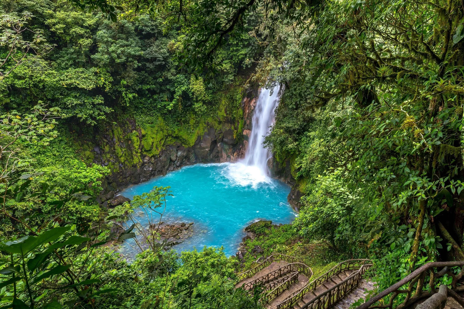 Turquoise waterfall pool surrounded by rainforest near Hideaway Rio Celeste.