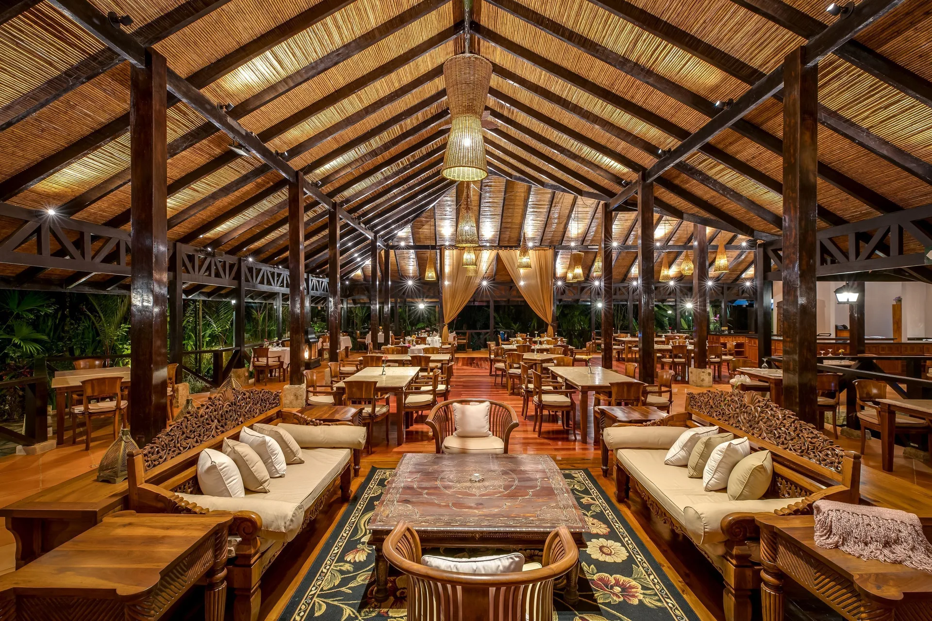 Open-air dining room and lounge seating under a pitched roof at Hideaway Rio Celeste.