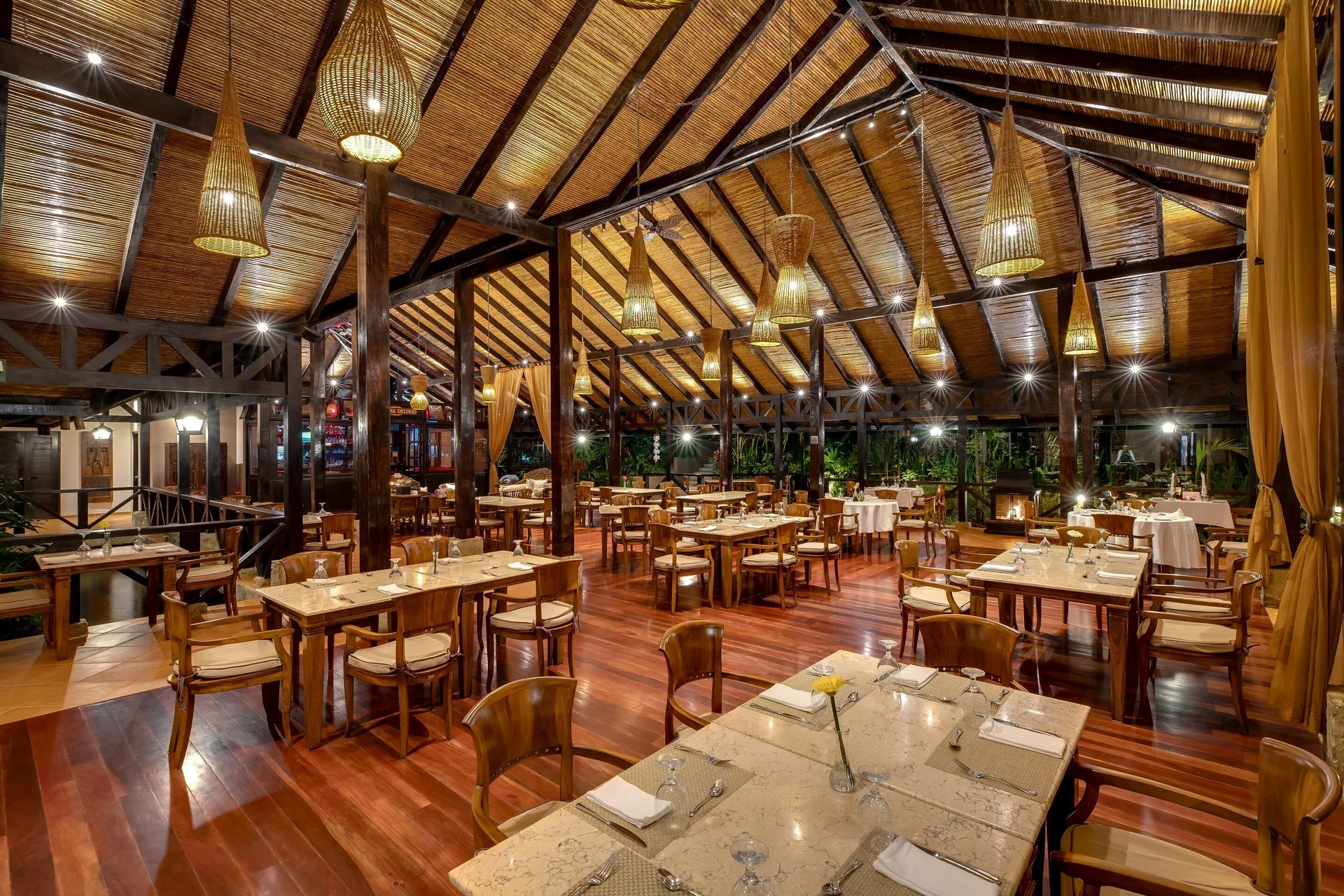 Set dining tables in a large timber-roofed restaurant at Hideaway Rio Celeste.