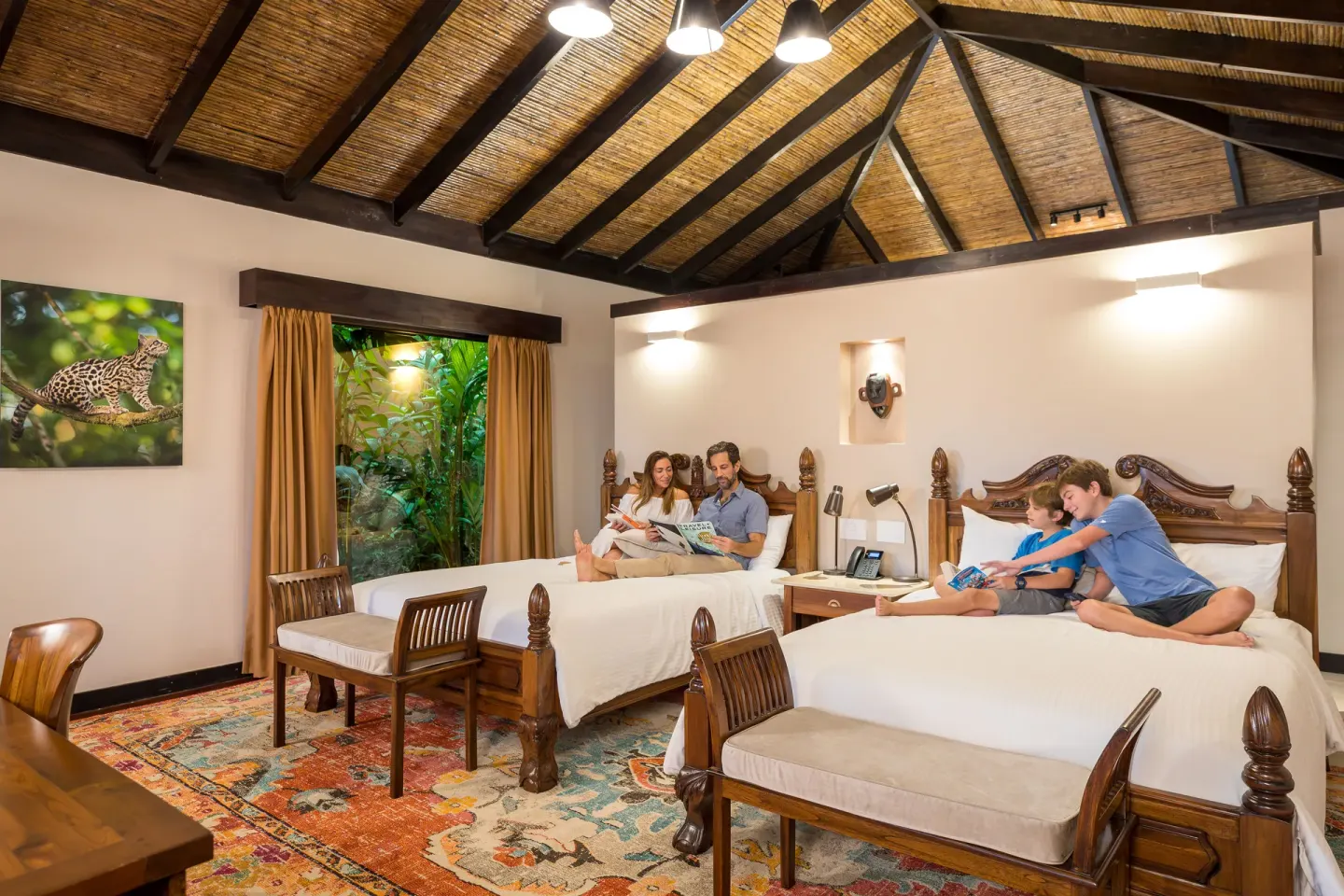 Guests relaxing on two Garden View Casita beds at Hideaway Rio Celeste.