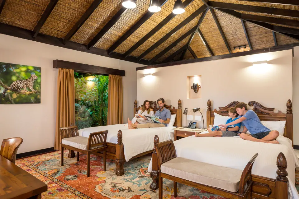 Guests relaxing on two Garden View Casita beds at Hideaway Rio Celeste.