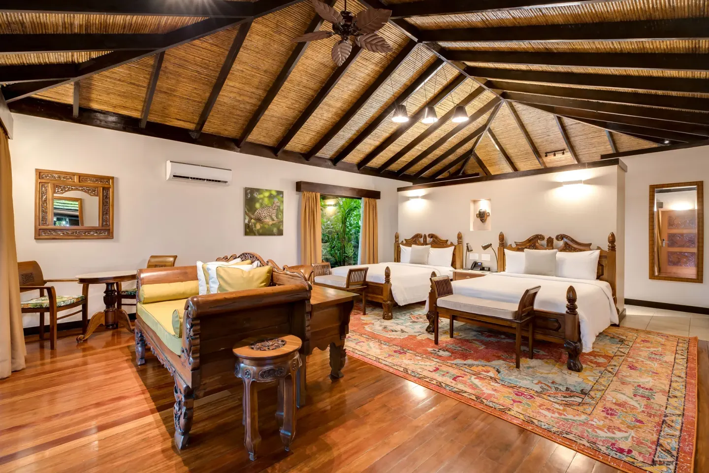 Wide view of a Garden View Casita with two beds and seating at Hideaway Rio Celeste.