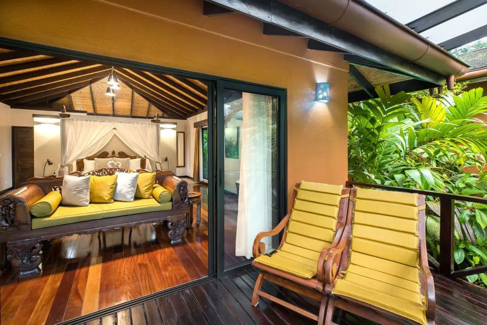 Garden View Casita at Hideaway Rio Celeste with terrace chairs outside the glass doors and bedroom beyond.