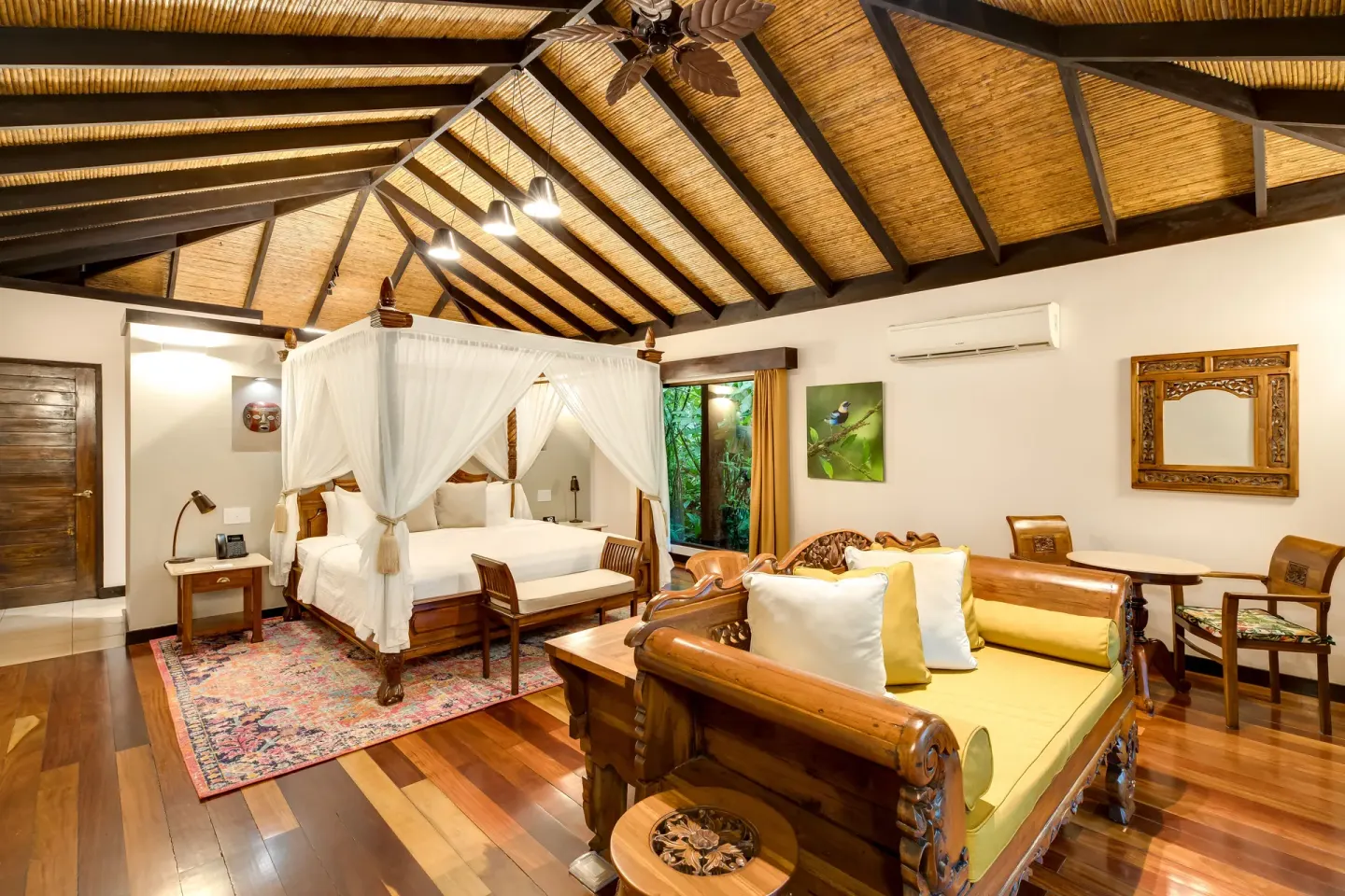 Garden View Casita at Hideaway Rio Celeste with canopy bed, carved sofa, wood floors, and vaulted ceiling.