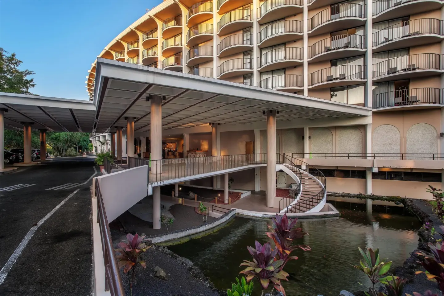 Covered entrance, balconies, and koi pond area at Hilo Hawaiian Hotel.
