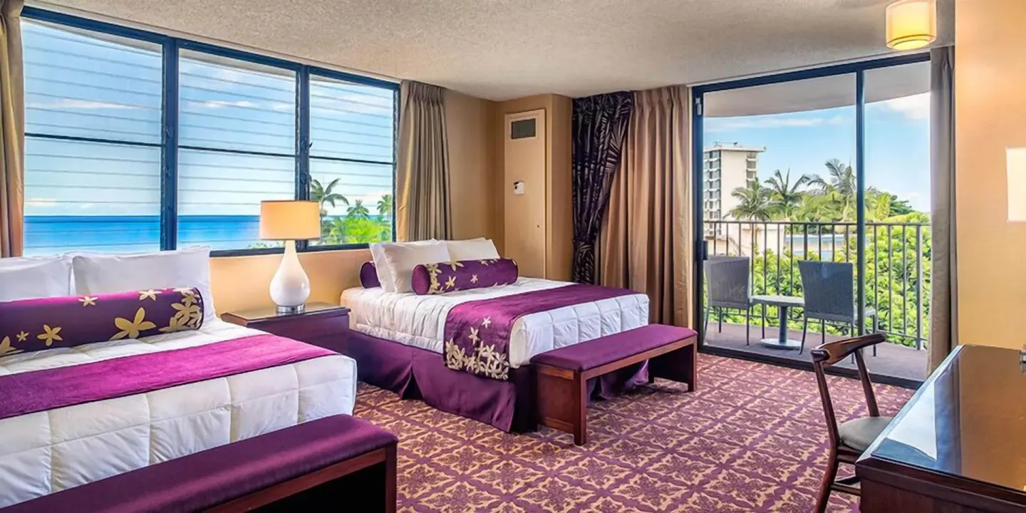 Guest room with two beds, ocean-facing windows, and balcony at Hilo Hawaiian Hotel.