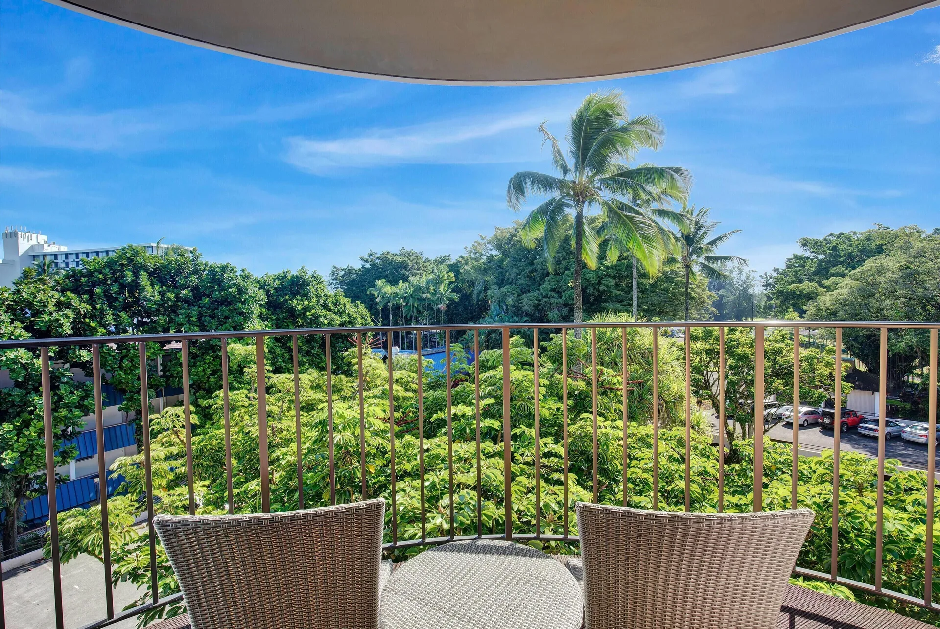 Balcony seating overlooking banyan trees from a guest room at Hilo Hawaiian Hotel.