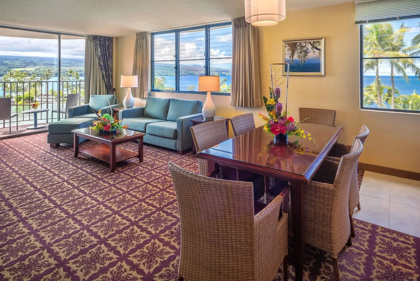 Oceanfront suite living and dining area with balcony views at Hilo Hawaiian Hotel.