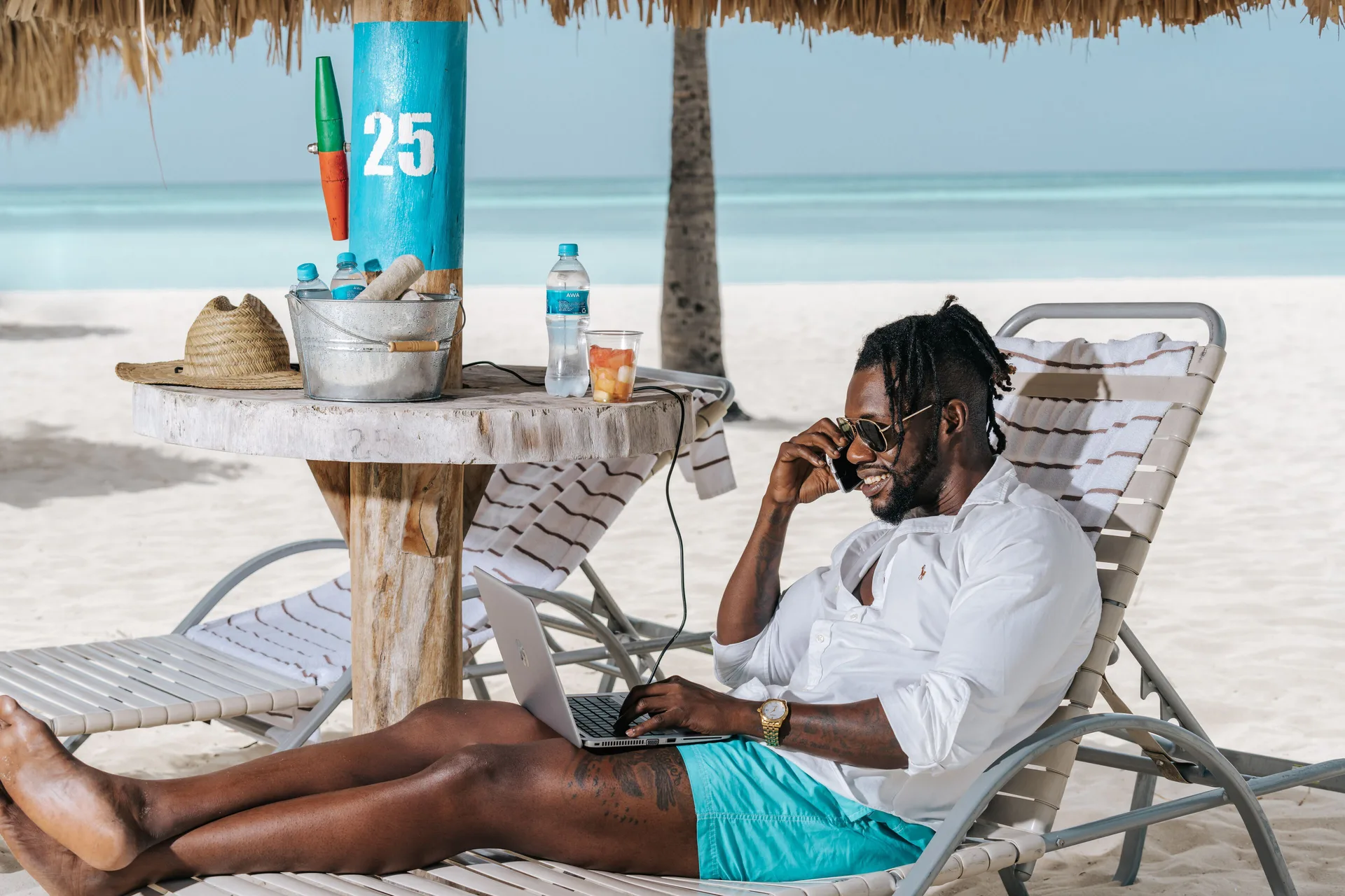 A guest works from a beach lounge chair at Hilton Aruba Caribbean Resort and Casino.