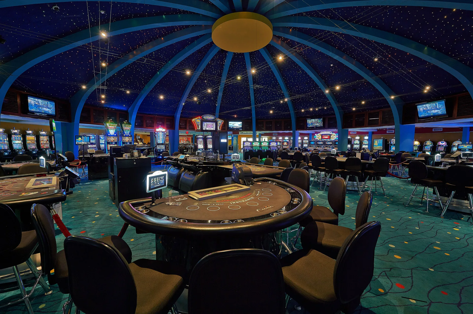 Casino tables and slot machines beneath a domed ceiling at Hilton Aruba Caribbean Resort and Casino.