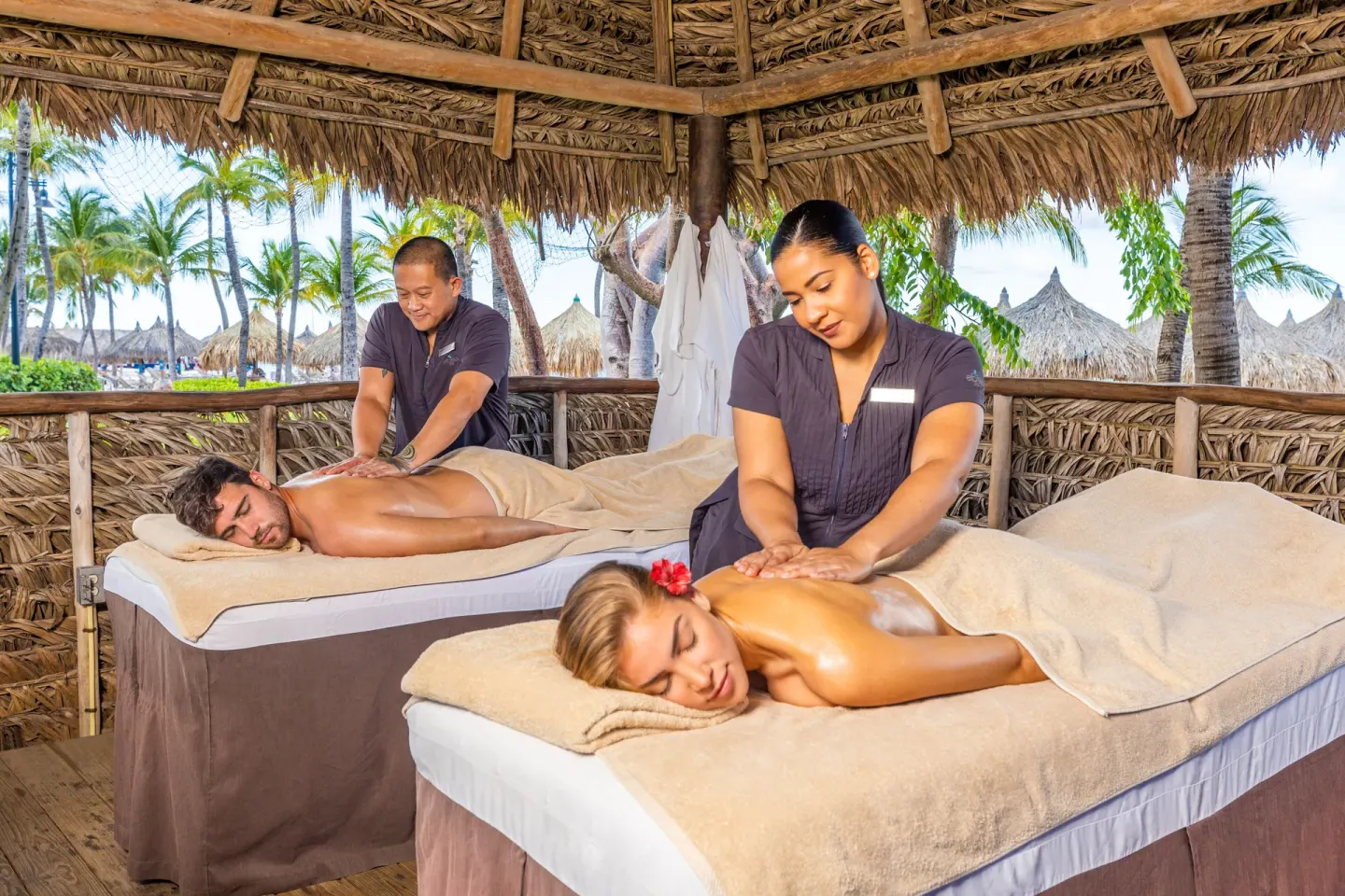 Couples massages in a thatched beach cabana at Hilton Aruba Caribbean Resort and Casino.