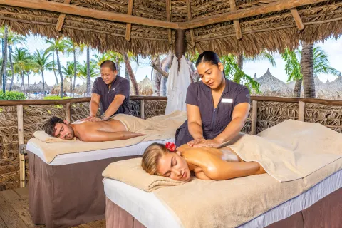 Couples massages in a thatched beach cabana at Hilton Aruba Caribbean Resort and Casino.
