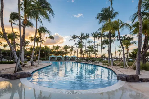 Palm-lined pool at sunset at Hilton Aruba Caribbean Resort and Casino.