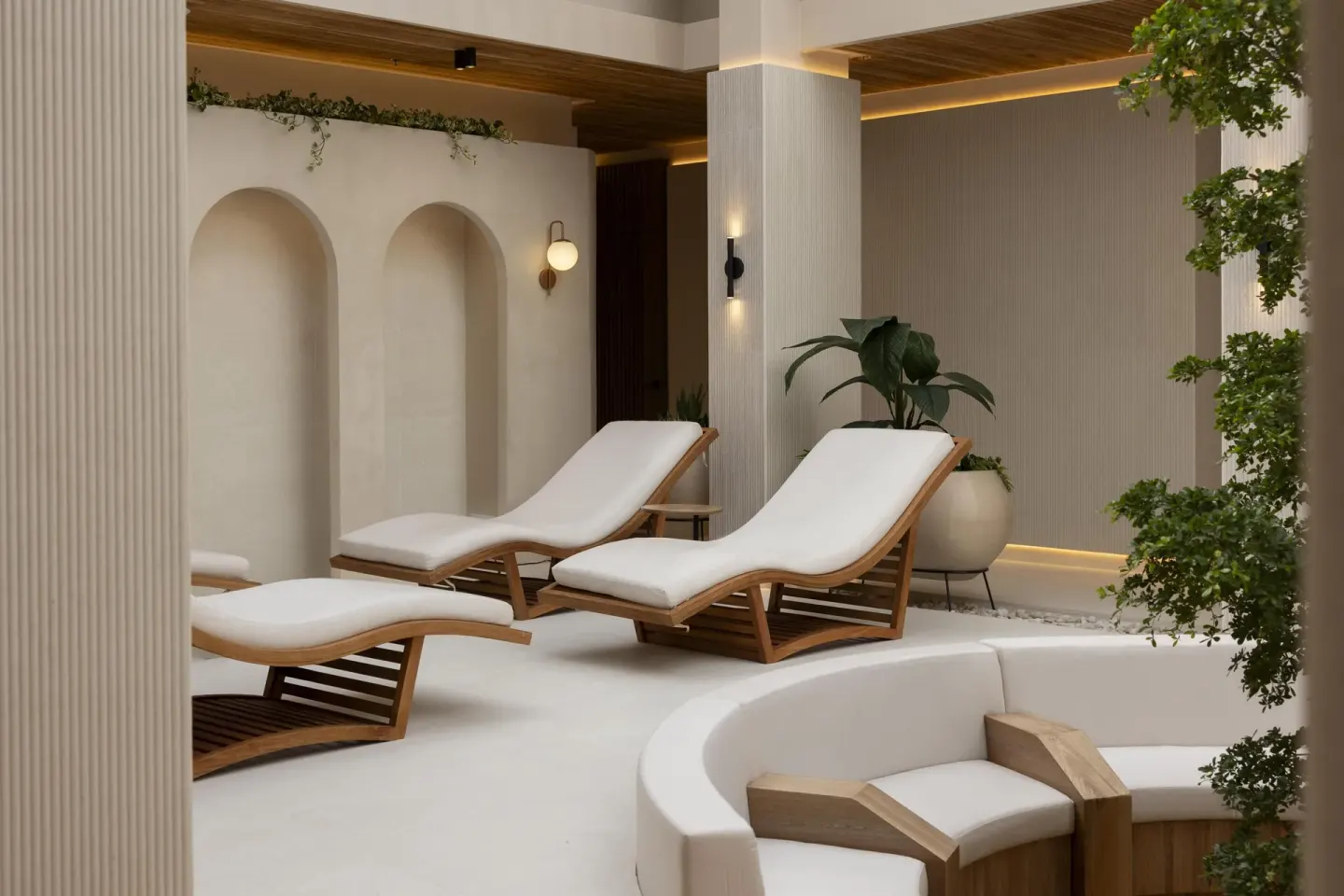 Spa lounge chairs with wood frames and white cushions at Hilton Aruba Caribbean Resort and Casino.