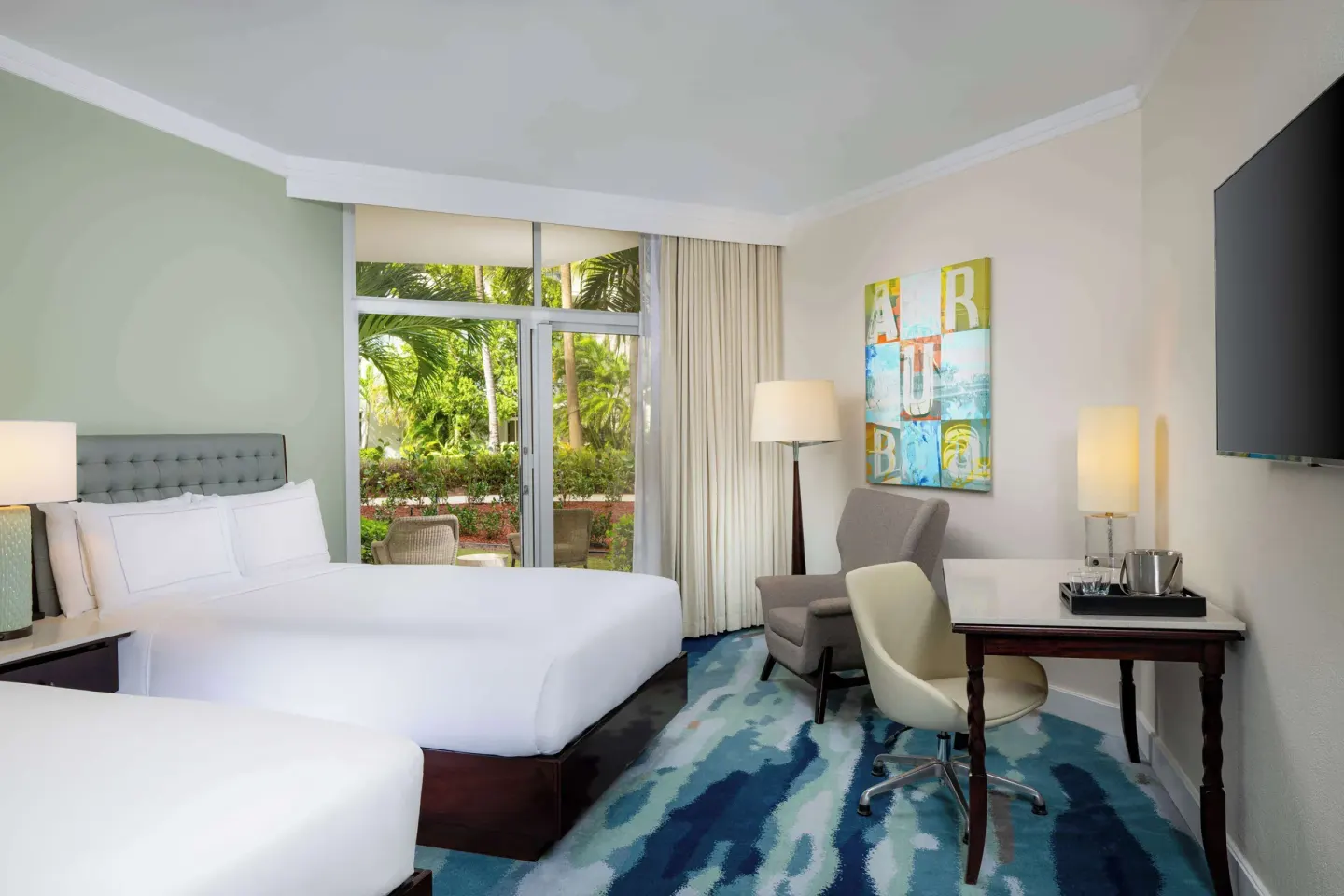 Garden-view room with two beds and a patio at Hilton Aruba Caribbean Resort and Casino.