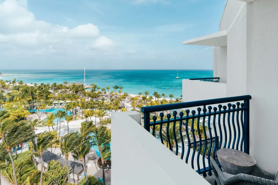 Aruba Tower balcony with blue railing and ocean view at Hilton Aruba Caribbean Resort and Casino.