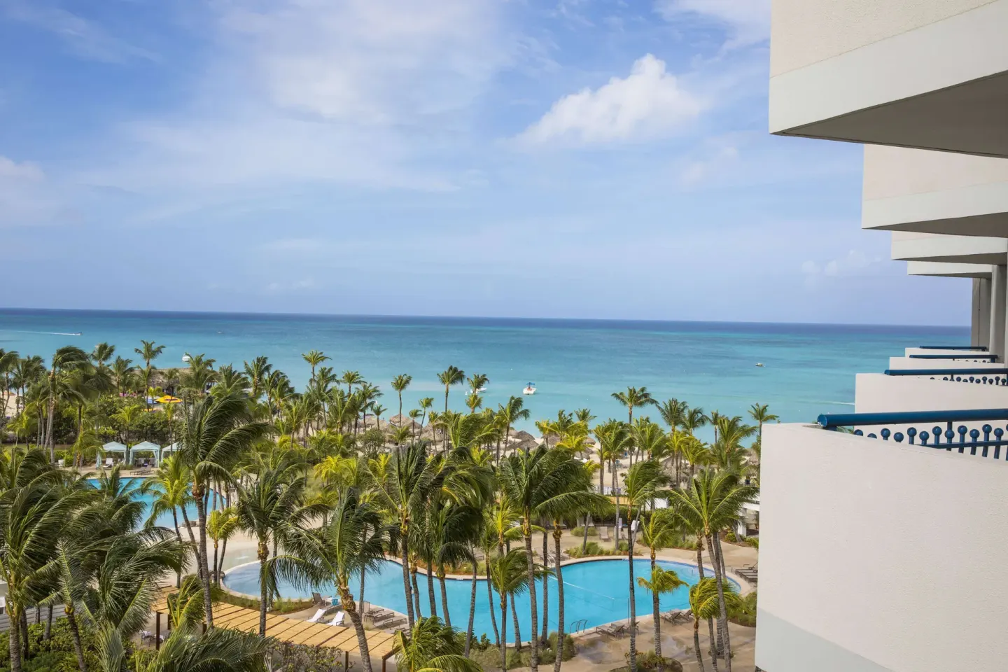 Ocean view from the Aruba Tower over pools and palms at Hilton Aruba Caribbean Resort and Casino.