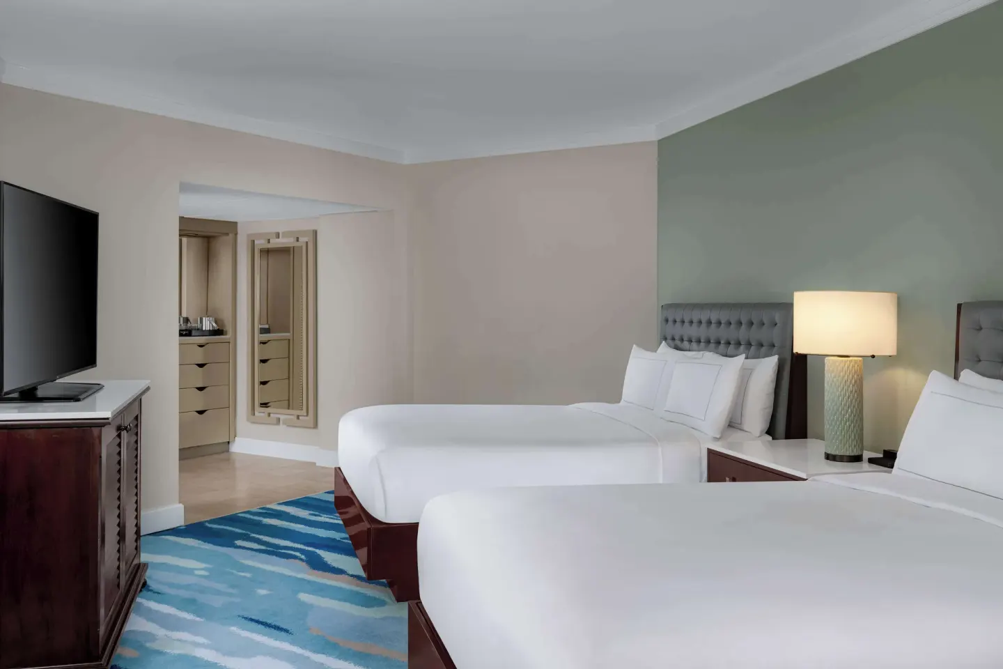Palm Beach Club room with two beds and entry closet area at Hilton Aruba Caribbean Resort and Casino.