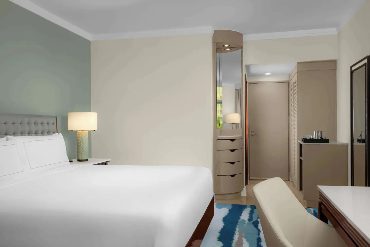 King guest room with bedside lamp and entry storage at Hilton Aruba Caribbean Resort and Casino.