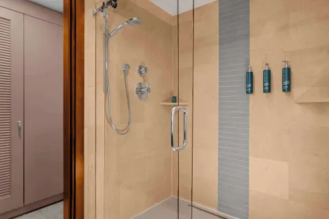 Suite bathroom glass shower with tiled walls at Hilton Aruba Caribbean Resort and Casino.