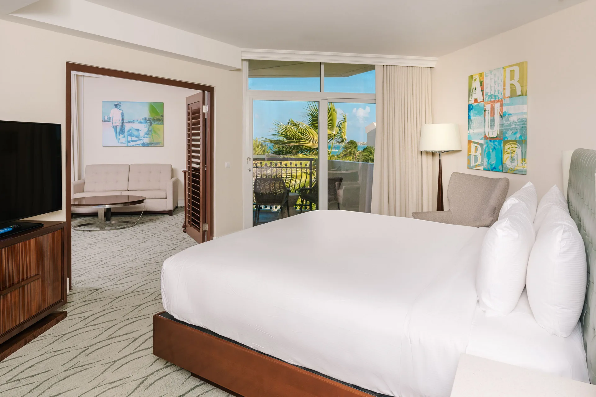 Suite bedroom with king bed and balcony at Hilton Aruba Caribbean Resort and Casino.
