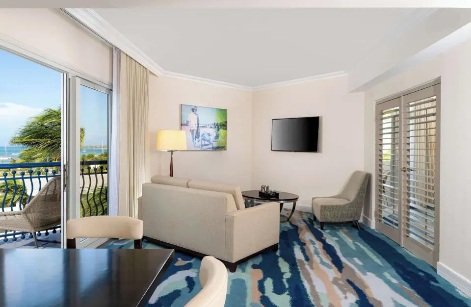 Suite living room with balcony seating and ocean view at Hilton Aruba Caribbean Resort and Casino.