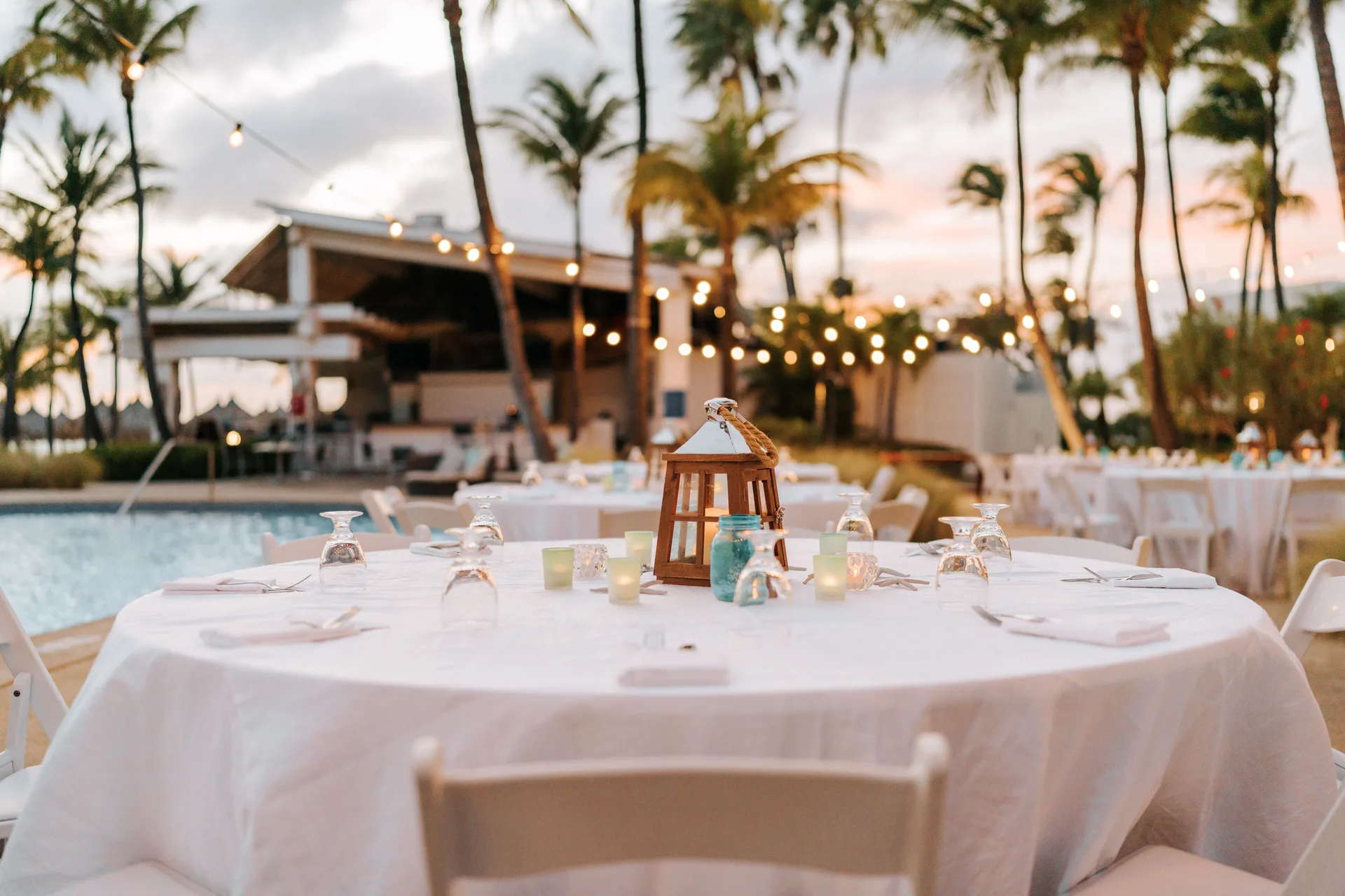 Outdoor event table by the pool at Hilton Aruba Caribbean Resort and Casino at sunset.