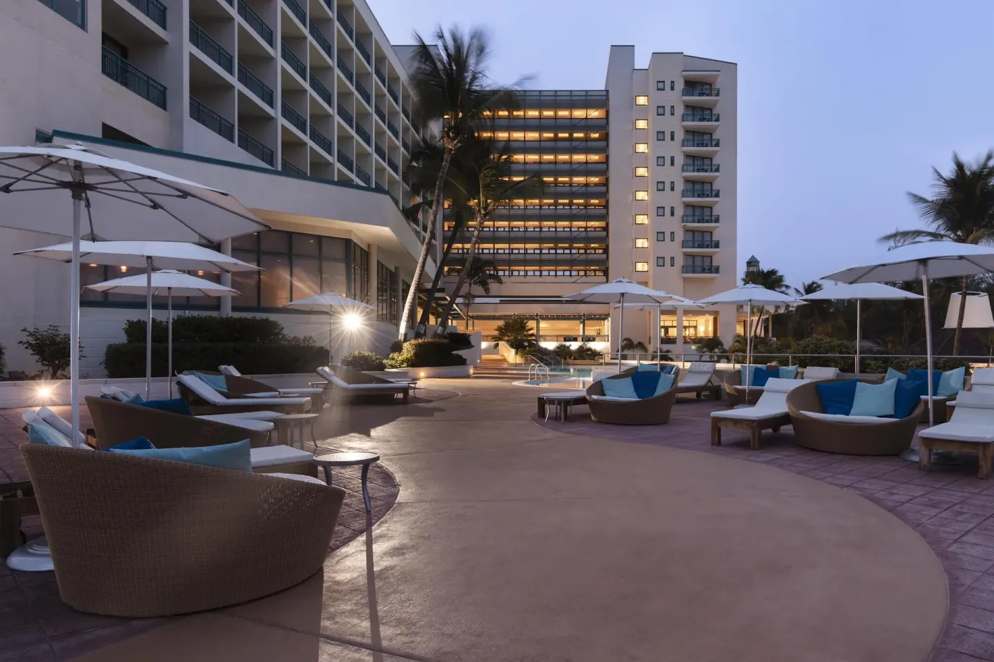 Evening pool terrace with lounge seating and guest towers at Hilton Barbados Resort.