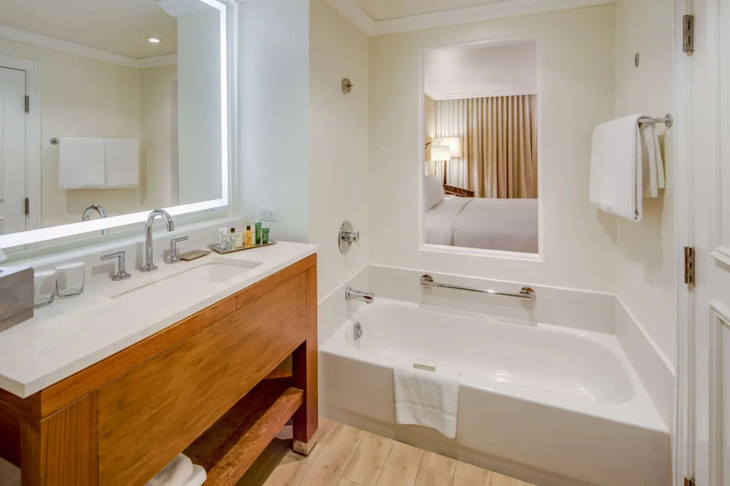 Guest bathroom with bathtub, vanity, and room window at Hilton Barbados Resort.