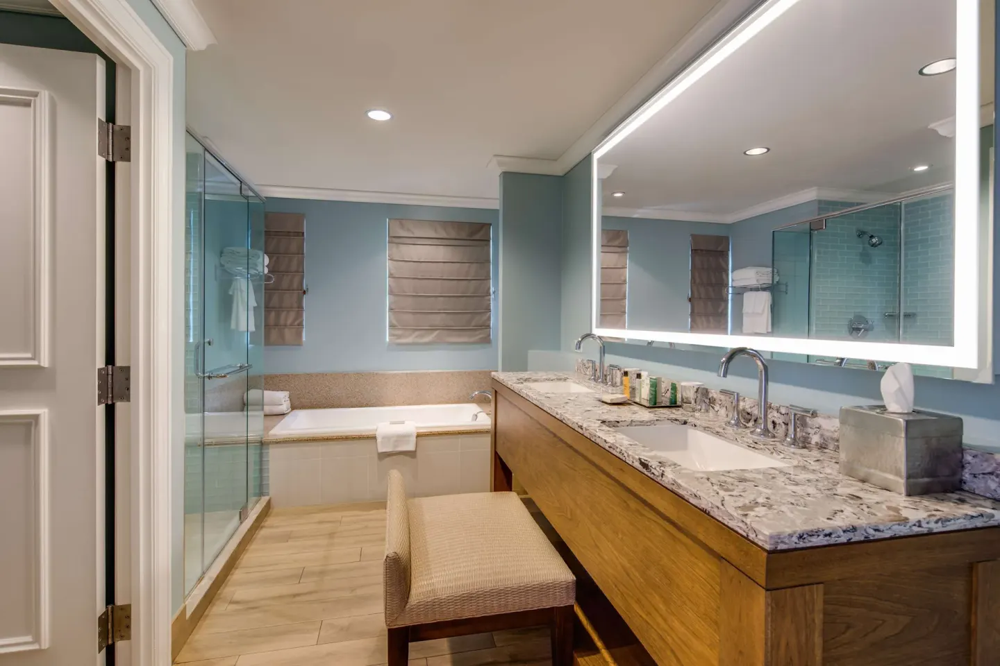 Spacious bathroom with double vanity, tub, and glass shower at Hilton Barbados Resort.