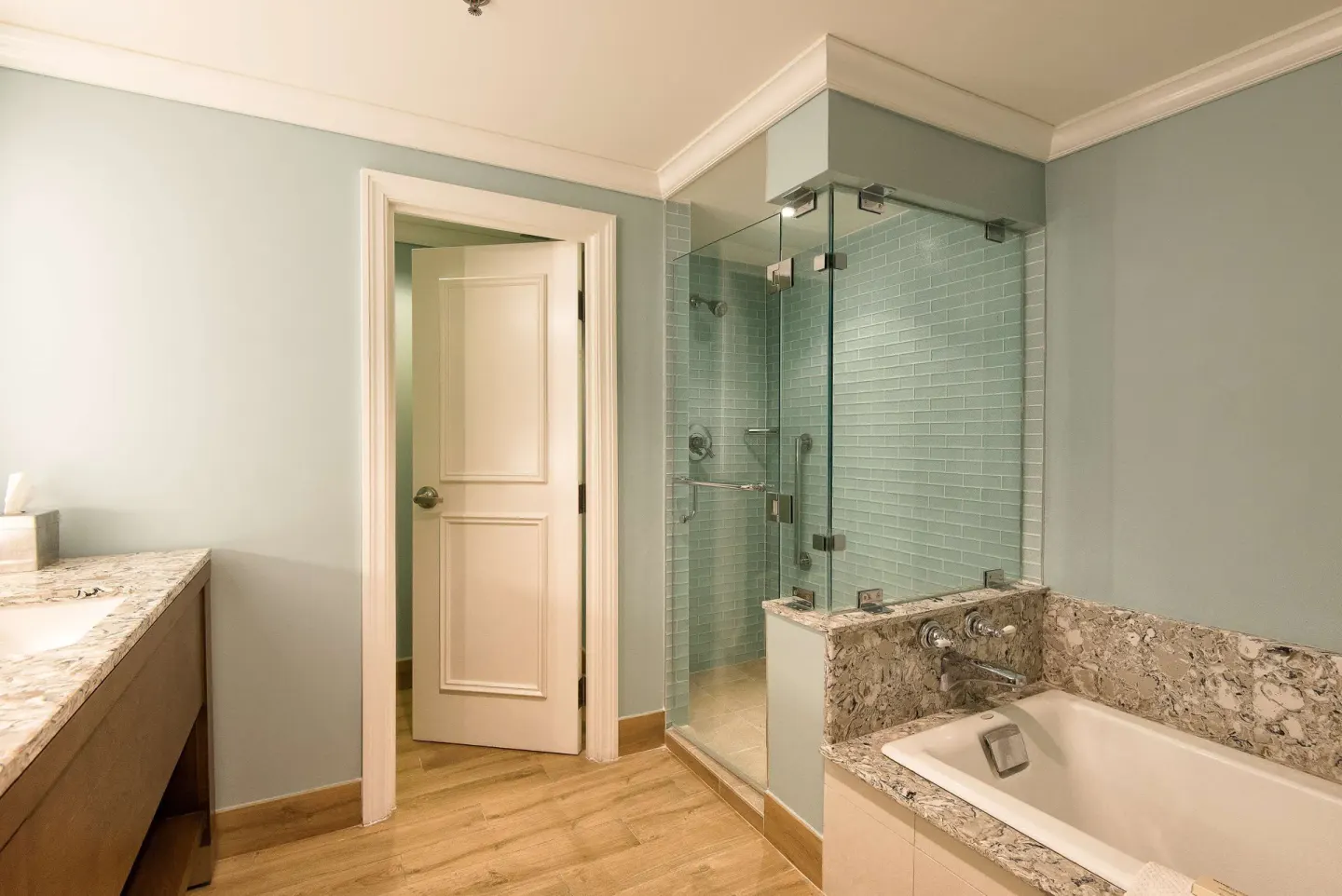 Guest bathroom with glass shower and bathtub at Hilton Barbados Resort.