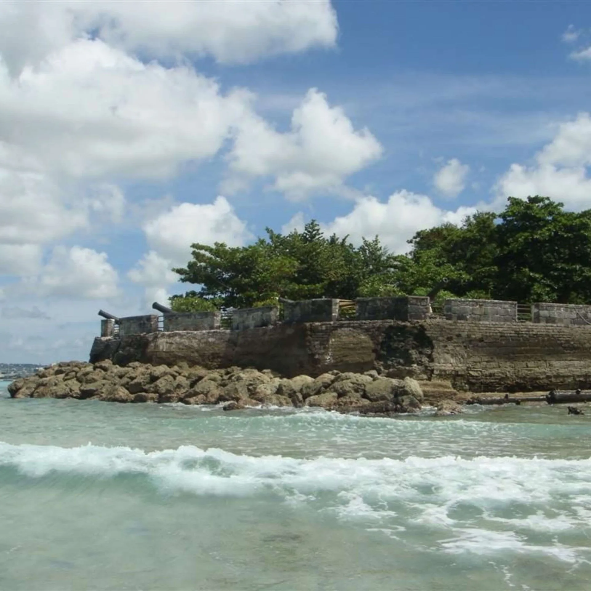 Stone fort wall and cannons above the beach at Hilton Barbados Resort.