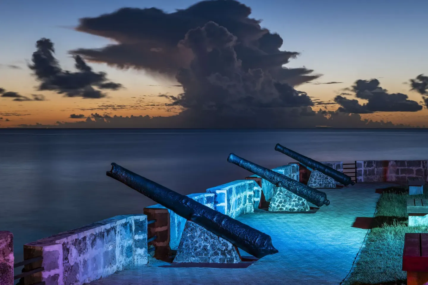 Historic cannons facing the ocean at dusk at Hilton Barbados Resort.