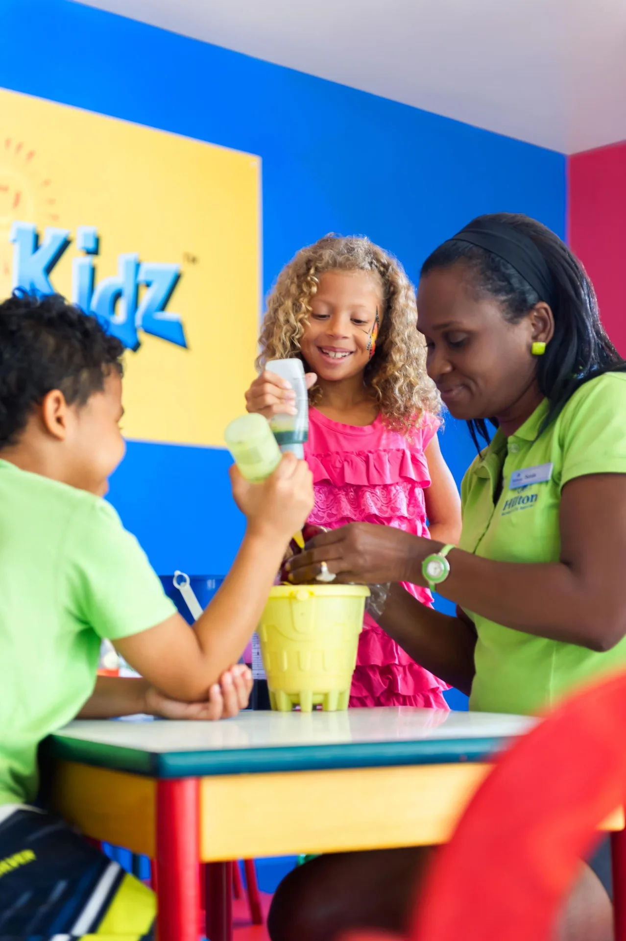 Children doing an activity with a staff member in the kids club at Hilton Barbados Resort.