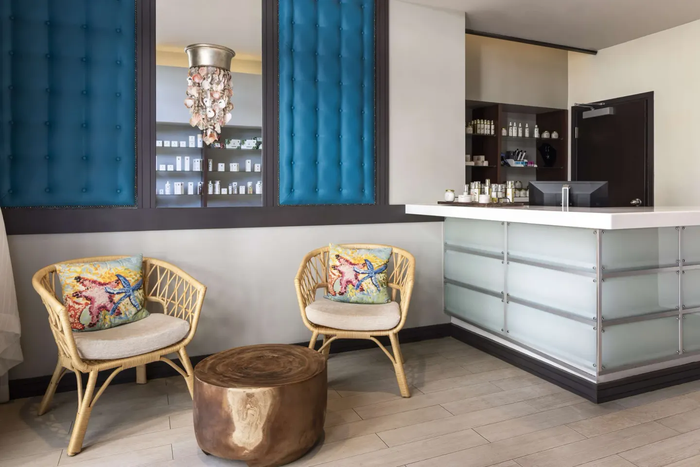 Spa reception desk with wicker chairs and blue wall panels at Hilton Barbados Resort.
