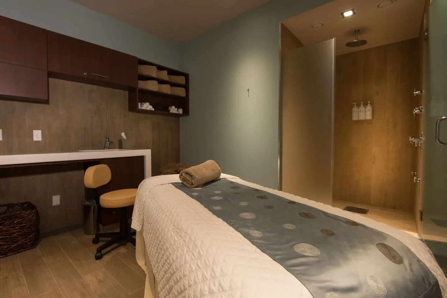 Spa treatment room with massage table and shower at Hilton Barbados Resort.