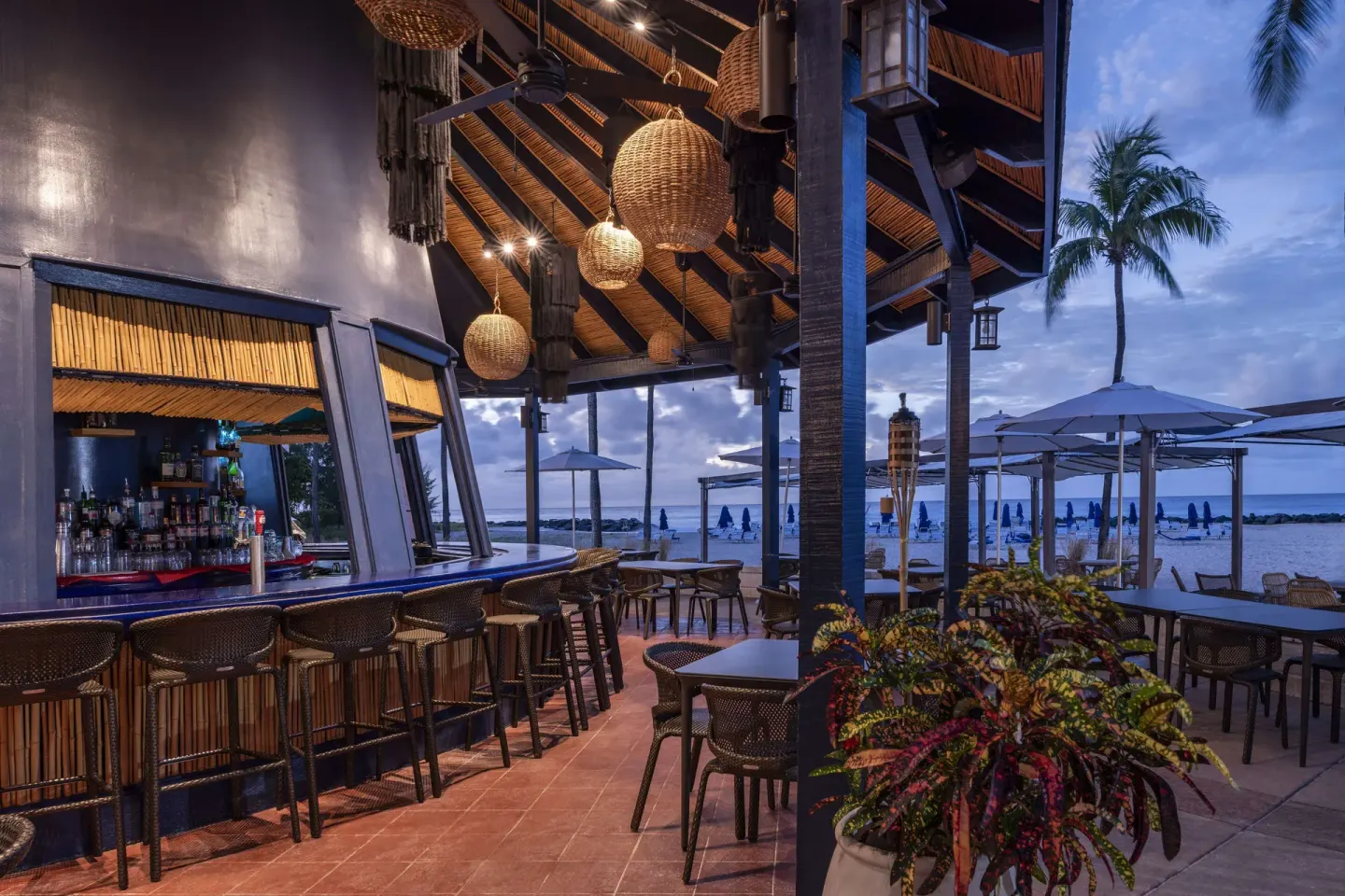 Open-air beach bar with counter seating and ocean views at Hilton Barbados Resort.