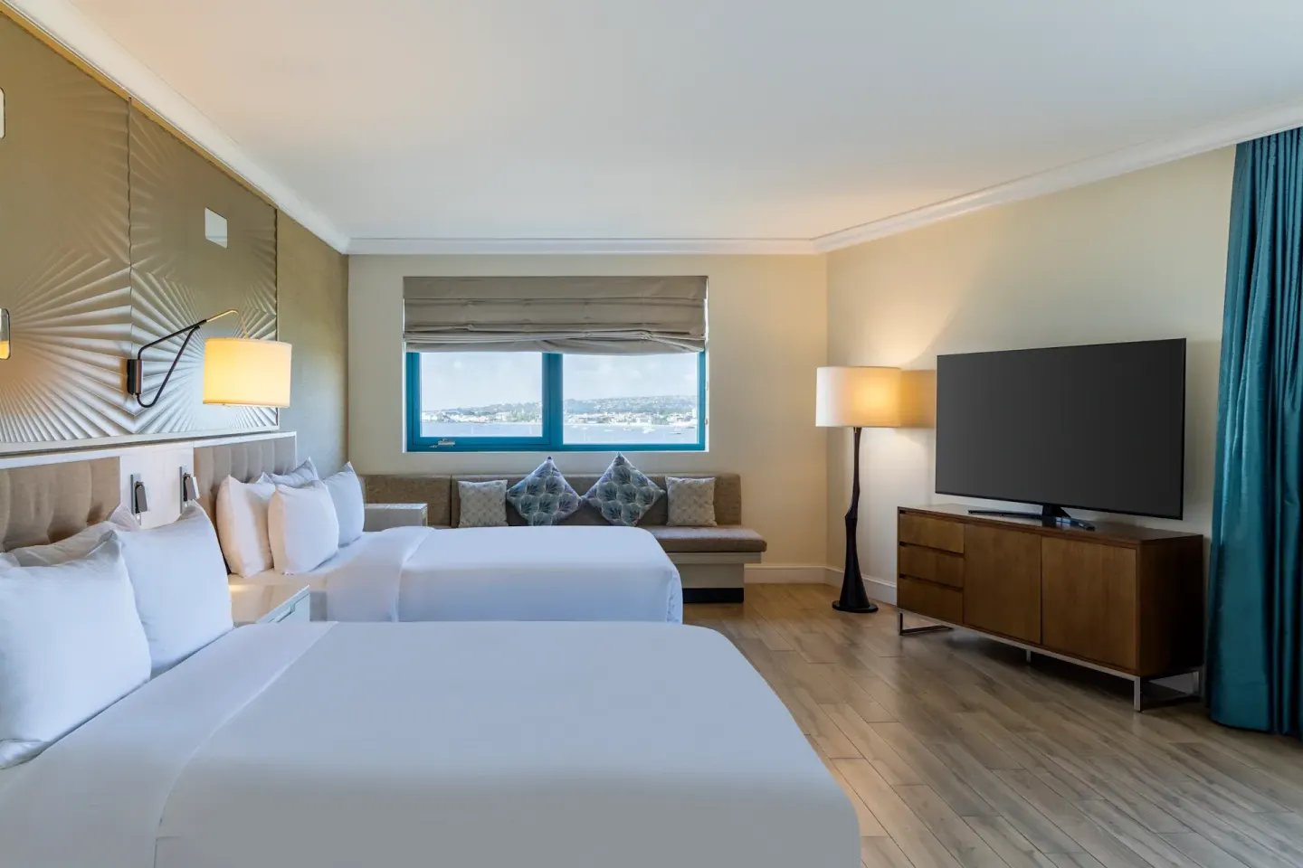 Bay View Two Room with two beds, seating area, and TV at Hilton Barbados Resort.